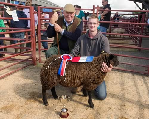 Robert Carruthers, Glenzierfoot, winner of Champion Prime Lamb at Longtown Young Farmers Club Lamb Show with judge Chris Brodie